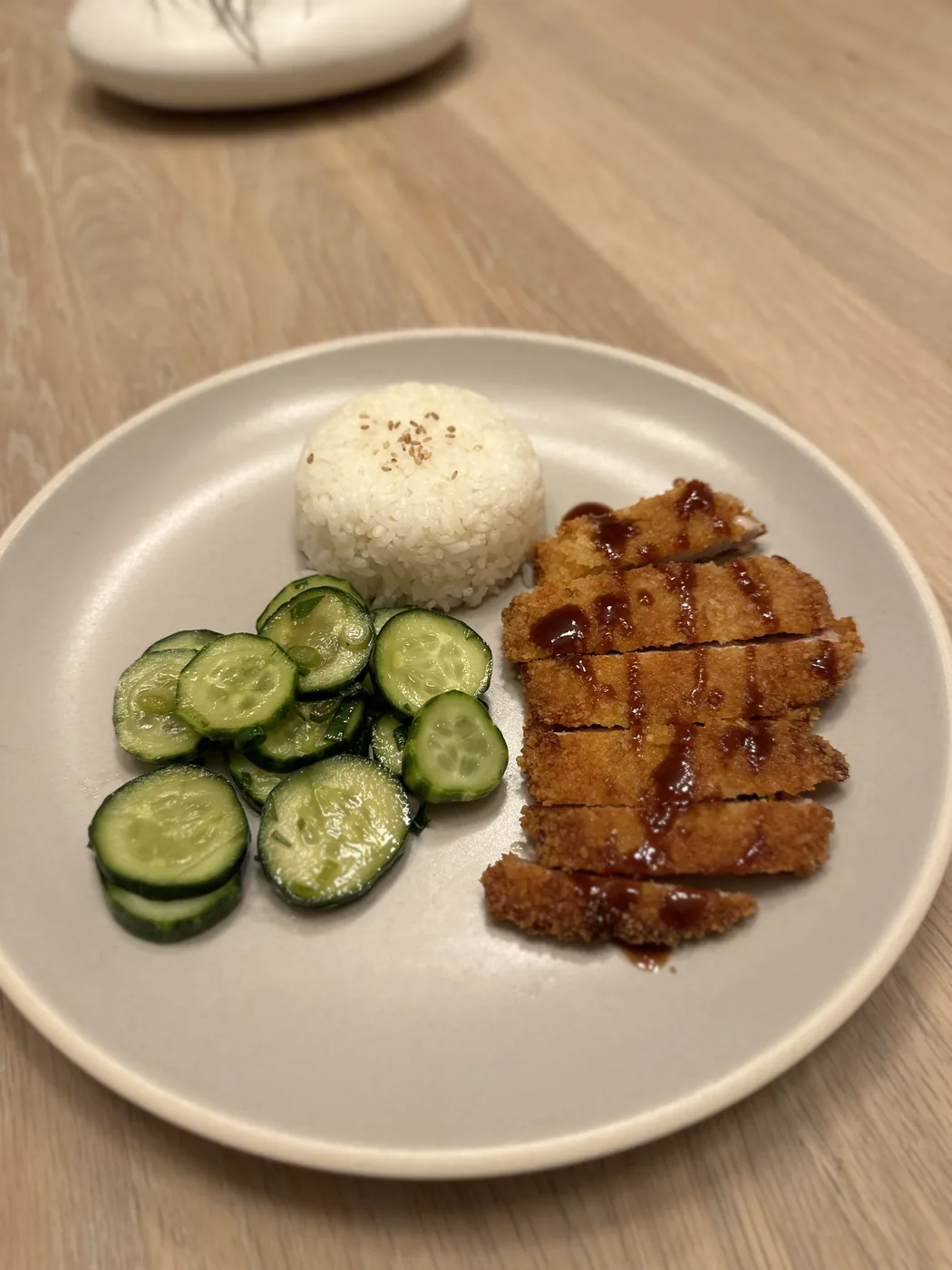 Chicken katsu with rice and cucumber salad plated for a weekly meal