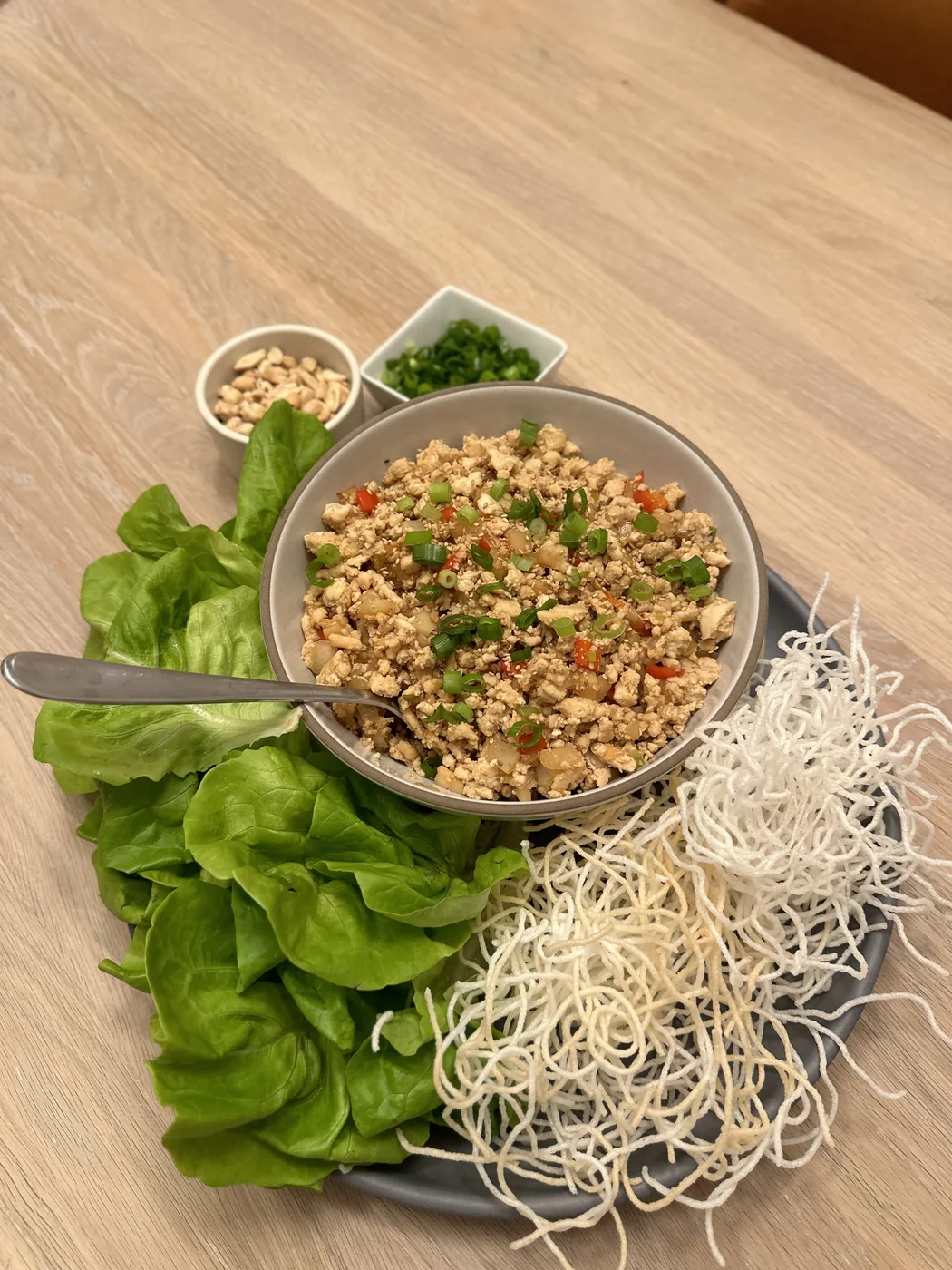 Lettuce wraps with savory filling, scallions, peanuts, and crispy noodles