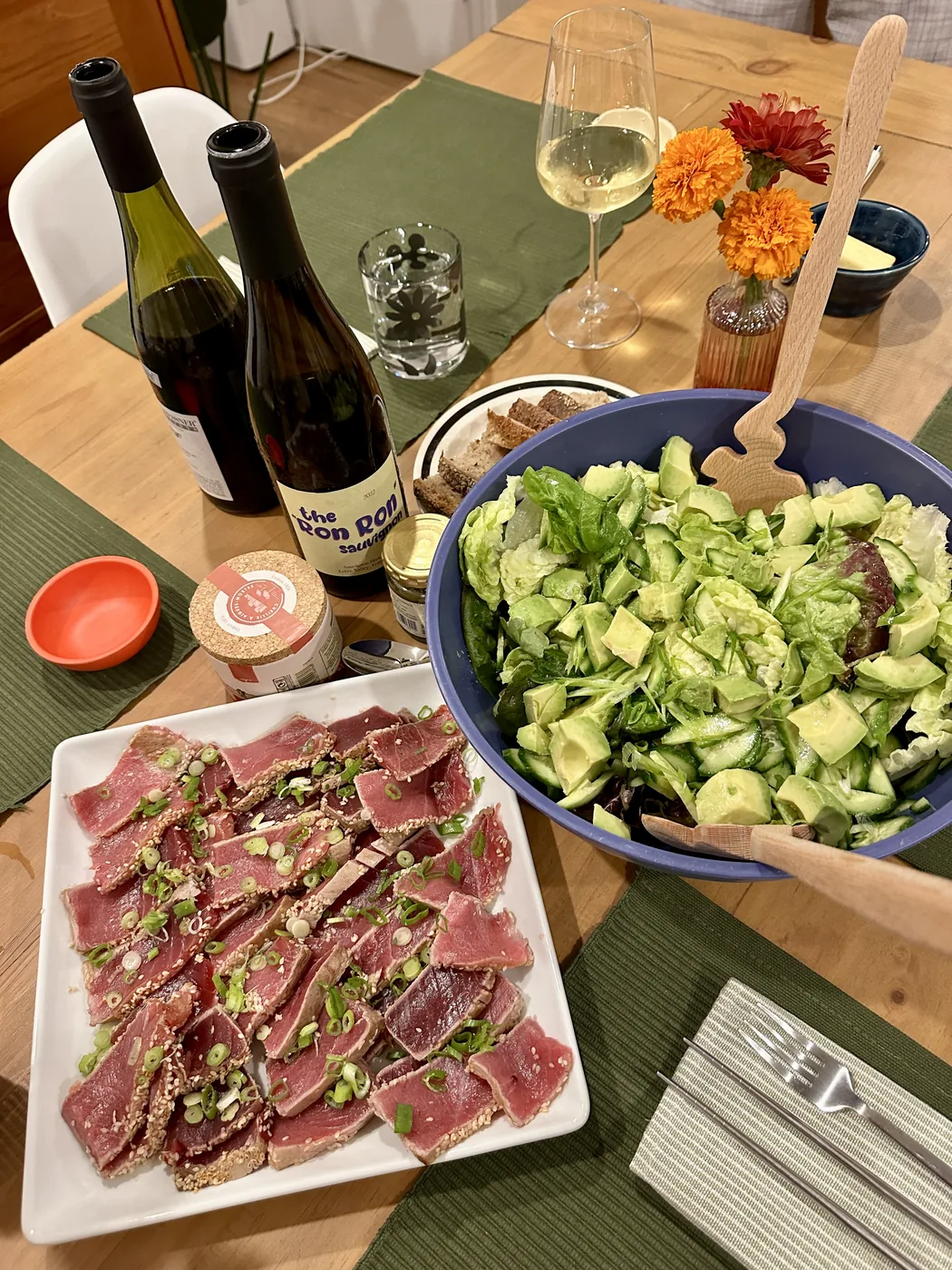 Seared ahi with scallions alongside a green salad and wine