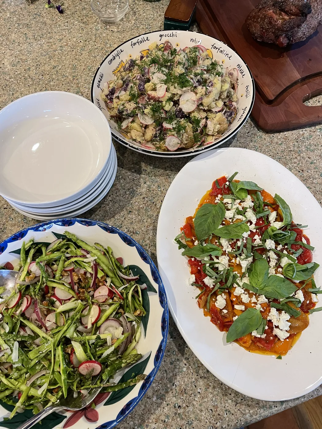 Colorful seasonal vegetable dishes and herbed potato salad