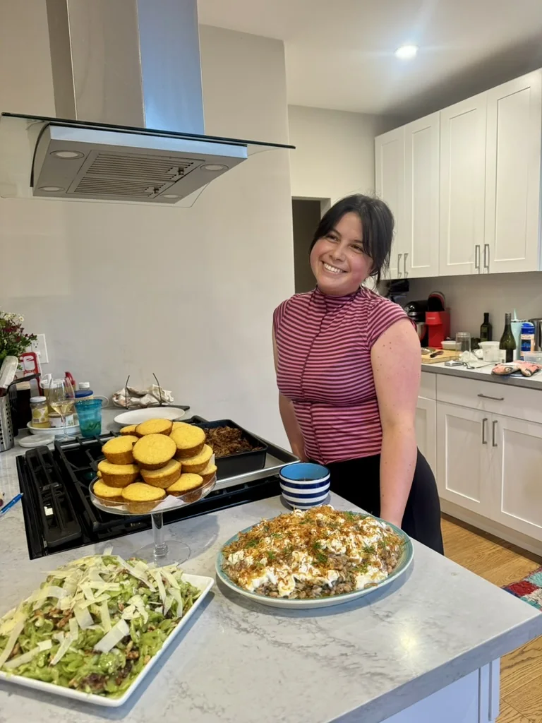 Tash smiling beside the finished bbq dinner spread