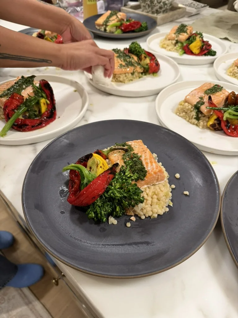 Plated salmon with greens and grilled seasonal vegetables
