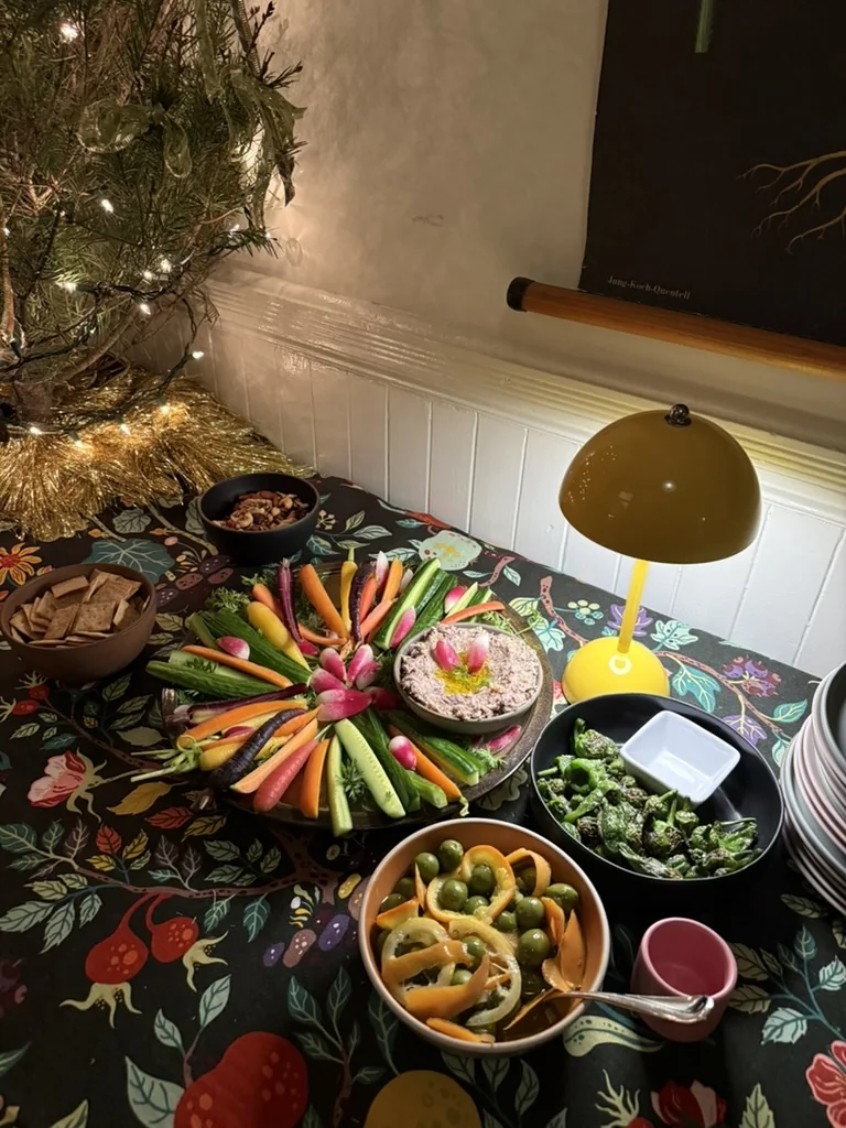 Holiday appetizer table with crudités, dips, dates, and olives